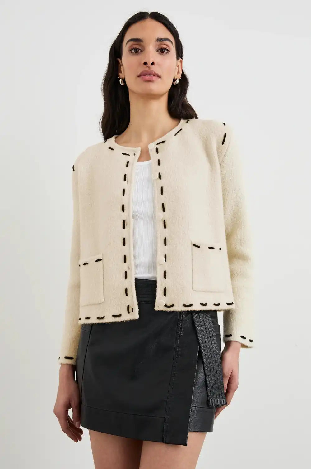 Cream-colored cardigan jacket with contrast stitching trim and front pockets.