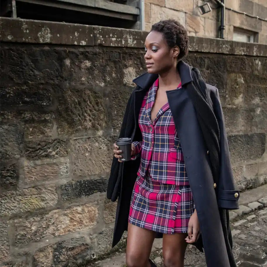 A plaid red and black shirt dress paired with a black wool coat.